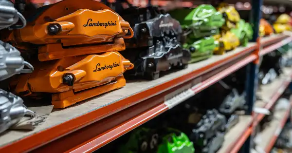 Colourful Lamborghini brake calipers on shelves in the Eurospares warehouse.